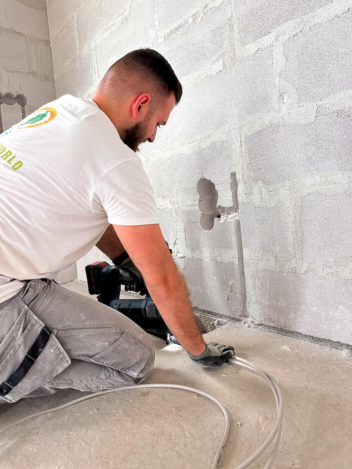 Elektroinstallateur bei der Leitungsverlegung im Rohbau