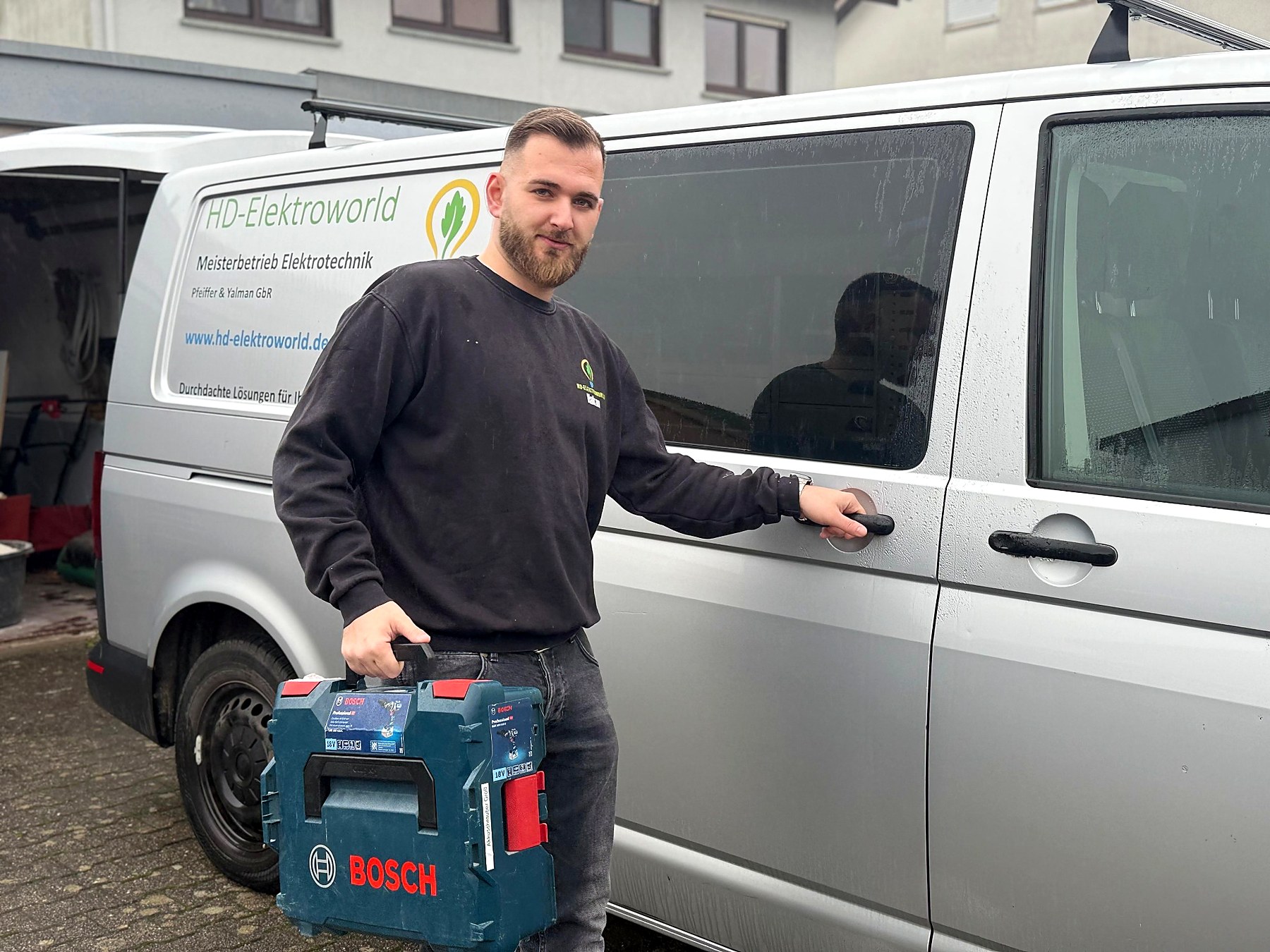 Elektromeister von HD Elektroworld vor dem Firmenfahrzeug